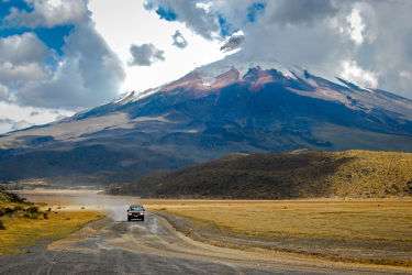 Dirt road in Ecuador with a snow capped volcano in the background