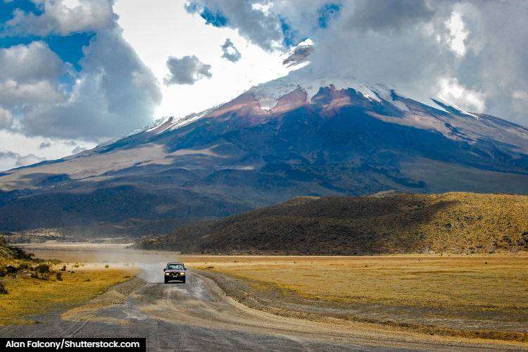 A gravel road with Cotopaxii volcano in the background